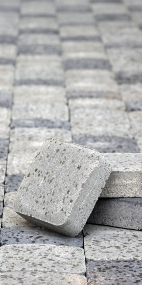 Small pile of gray walkway slabs lying in stack outdoors. Material for Paving Slabs